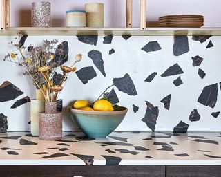 Large terrazzo tile backsplash in a stylish modern kitchen with wood cabinets Credit-Pluck