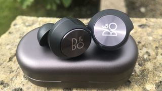 the beoplay eq true wireless earbuds on their charging case
