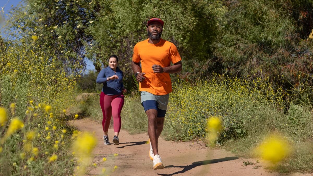 Promo image for Wear OS 5 showing two athletes running with Wear OS watches