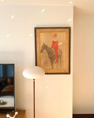 Picasso print dark brown wood classic frame on white wall with curved floor lamp in front