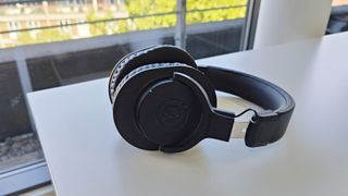 Audio-Technica ATH-M20xBT review: headphones from the side on a desk with trees in the background
