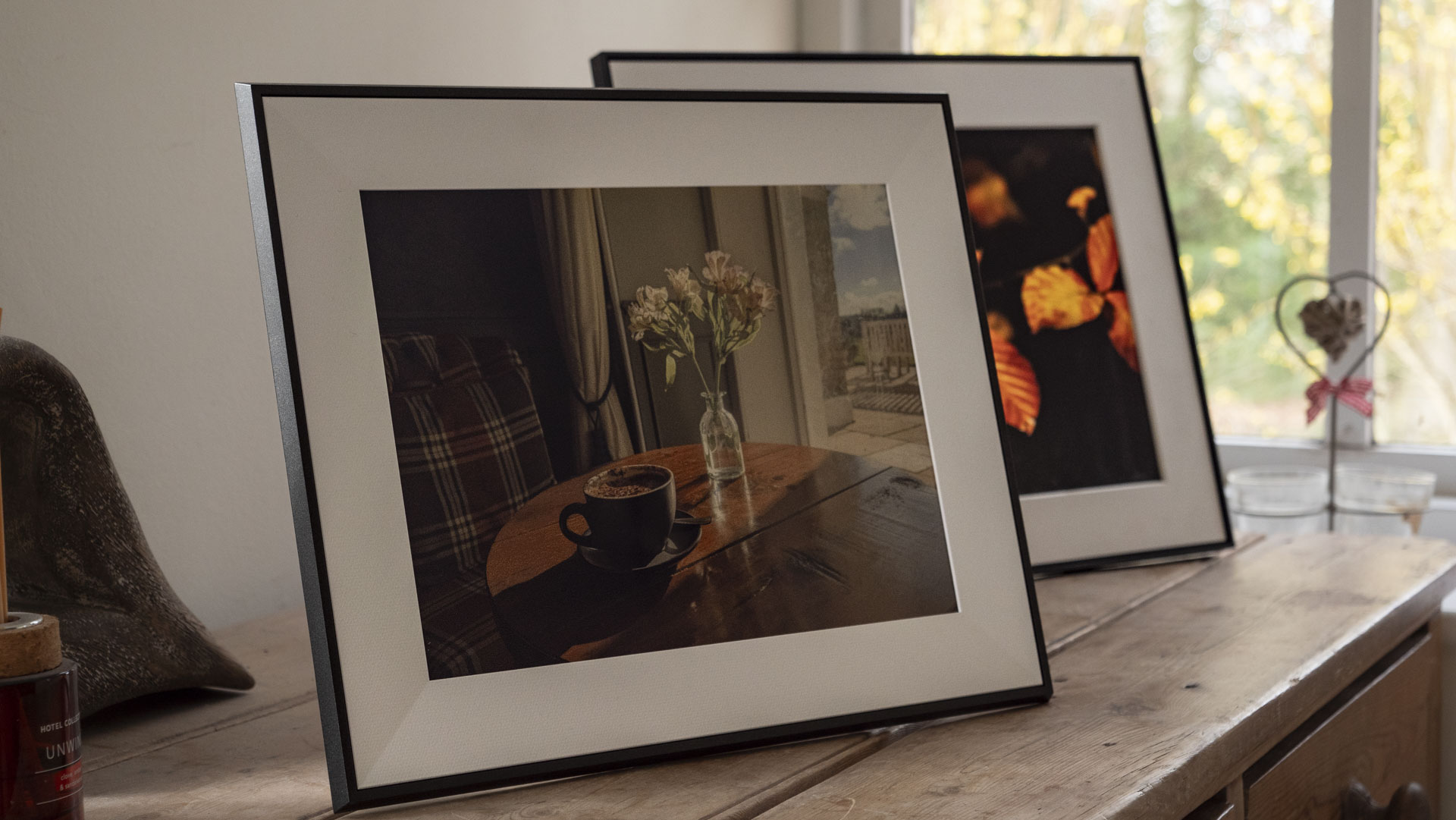 The Aura Ink 'E Ink' digital photo frame on a sideboard, alongside the Aura Walden frame