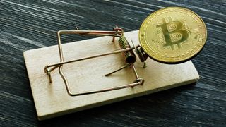 A physical Bitcoin placed in a mousetrap as a lure.