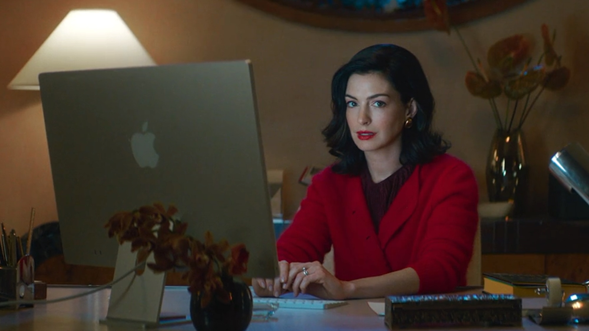 Anne Hathaway at a computer desk in Verity