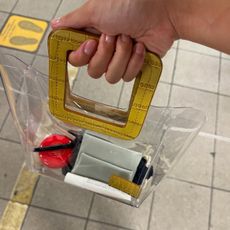 A woman holding a clear handbag with makeup products in