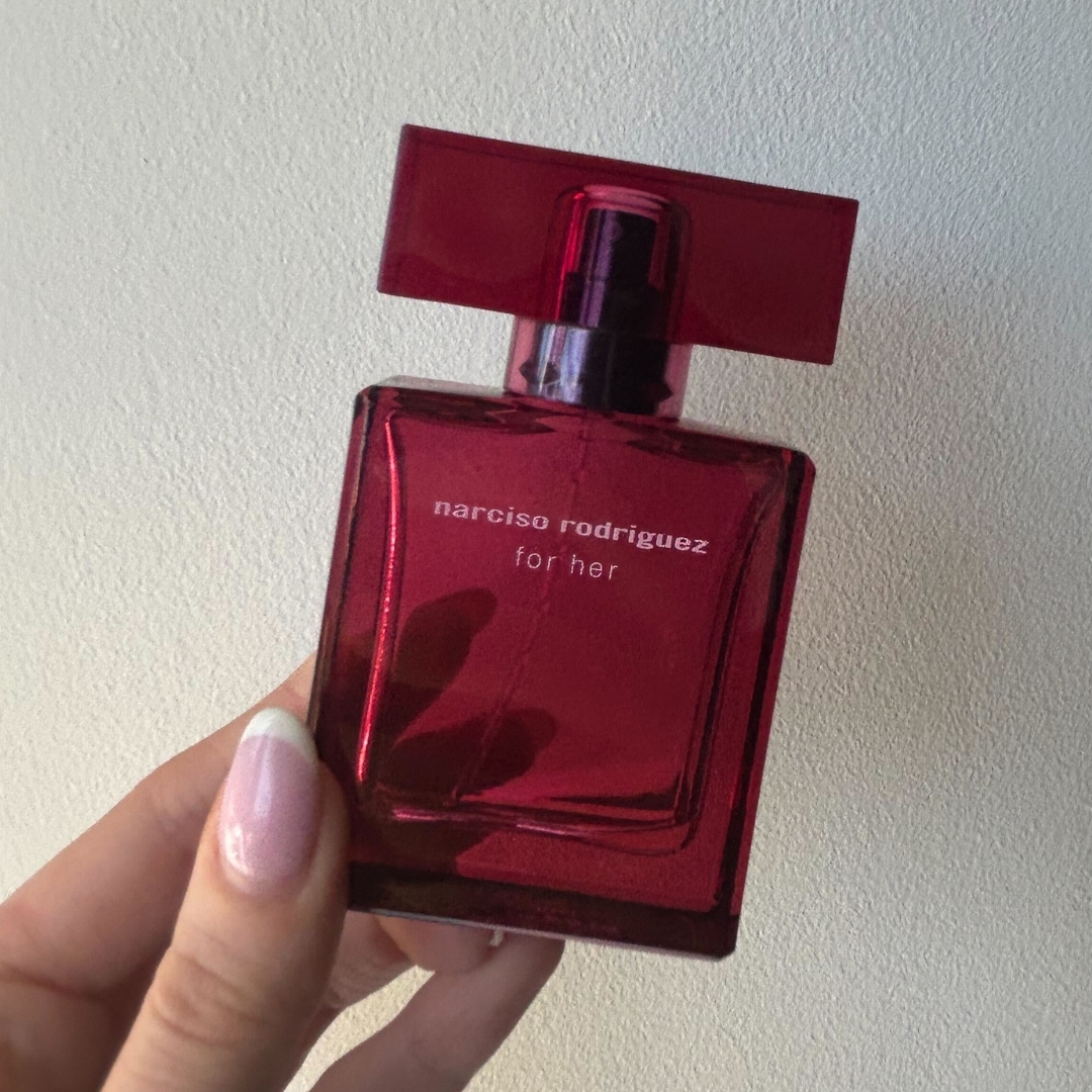 Hand holding empty bottle of Narciso Rodriguez For Her Eau De Parfum Intense