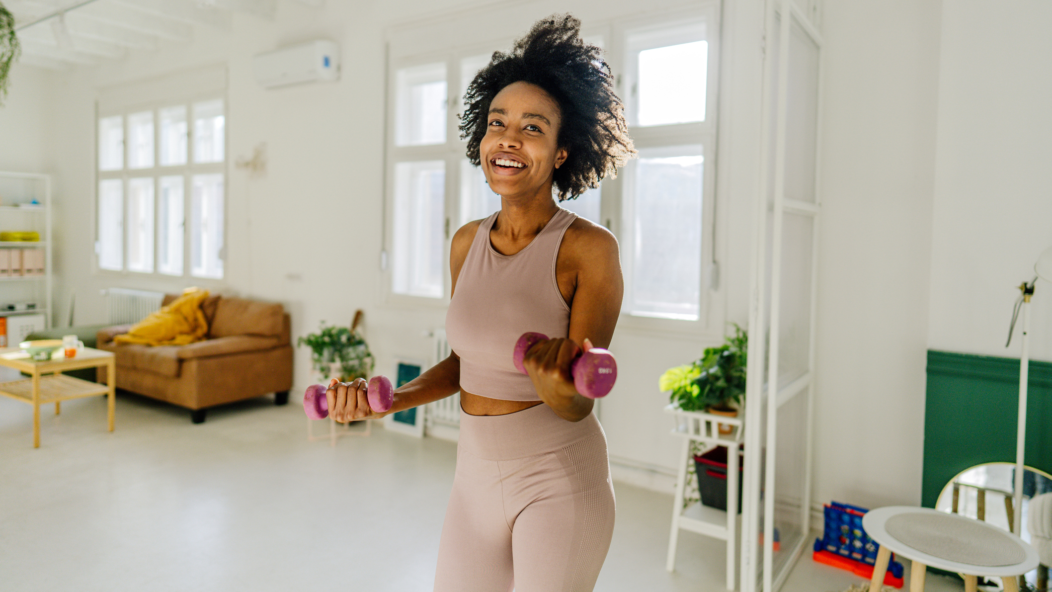 Woman exercising with dumbbells at home