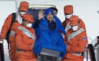 A Shenzhou 14 astronaut waves after landing in Beijing following the successful completion of the Shenzhou 14 mission. The three-person Shenzhou 14 spent six months at China's Tiangong space station and ended with a touchdown on Dec. 4, 2022.