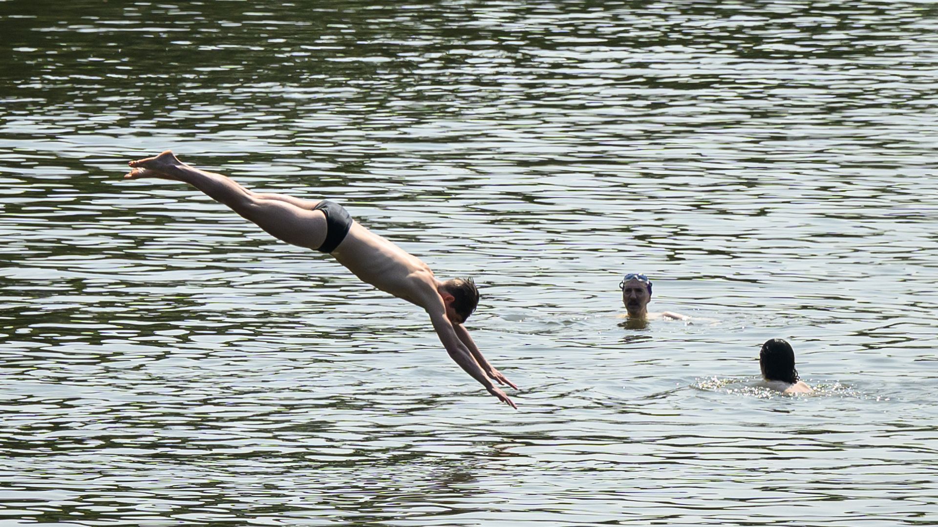 LONDON, UNITED KINGDOM - JUNE 19: A man dives into one of the swimming ponds on Hampstead Heath on June 19, 2025 in London, United Kingdom. Yellow heat health alerts have been issued by the Met Office with temperatures set to climb as high as 33C by the weekend.