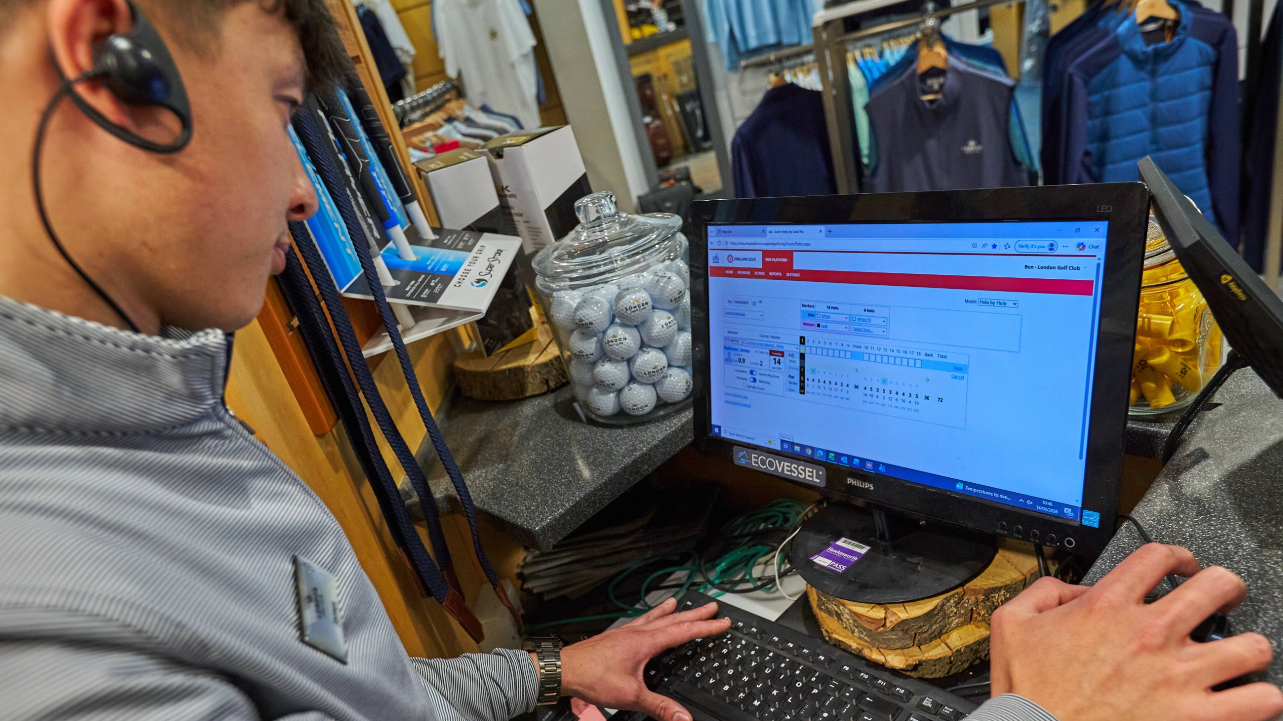 Golf pro looking at computer screen in pro shop