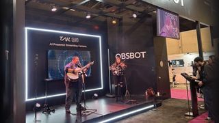 Guitarist and violinist playing live on the Obsbot stand at NAB to demonstrate the Tail Air