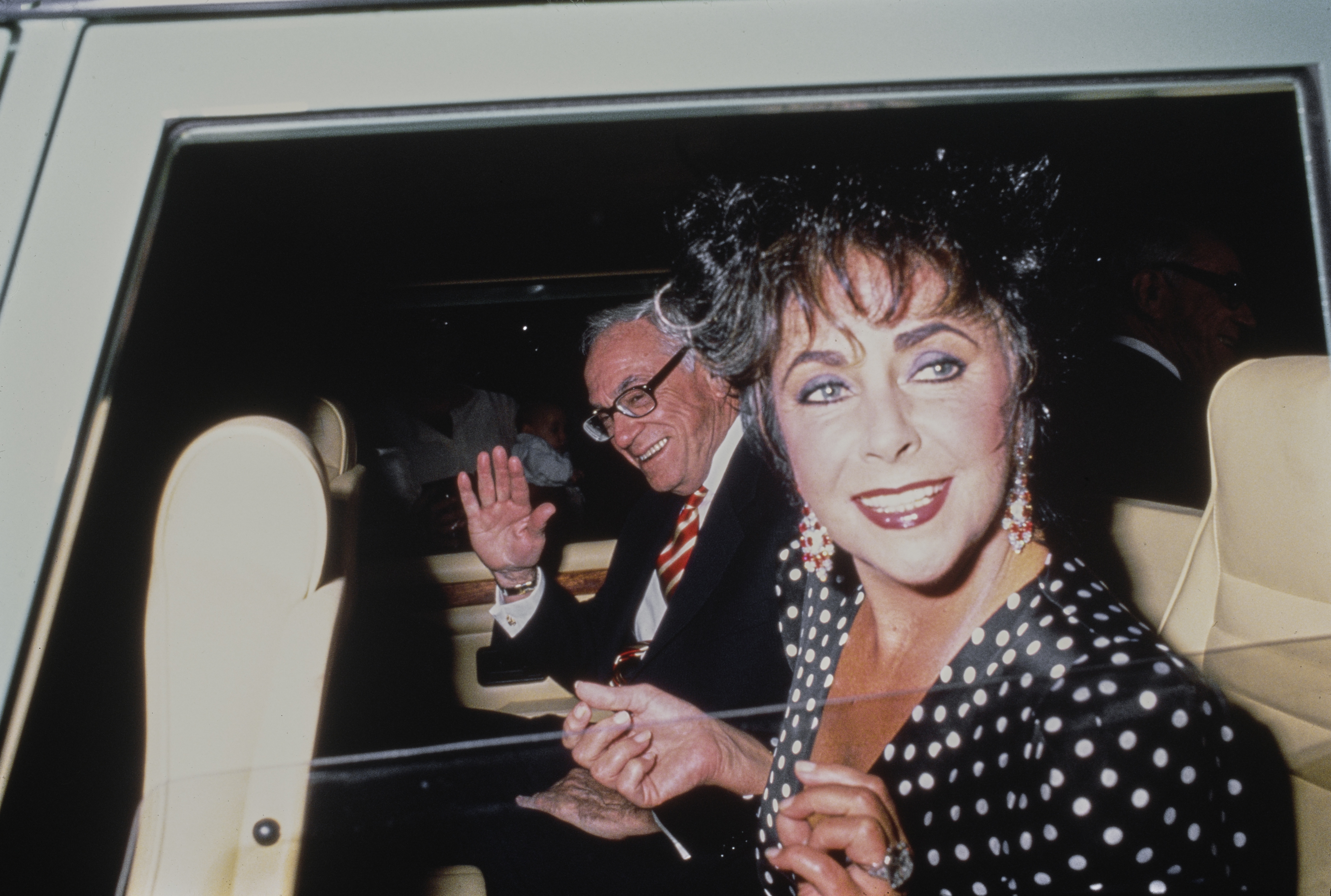 American publisher and politician Malcolm Forbes beside British-American actress Elizabeth Taylor, circa 1983.
