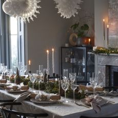 white dining table with Christmas foliage and candles