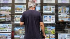 Man looking in the window of an estate agent