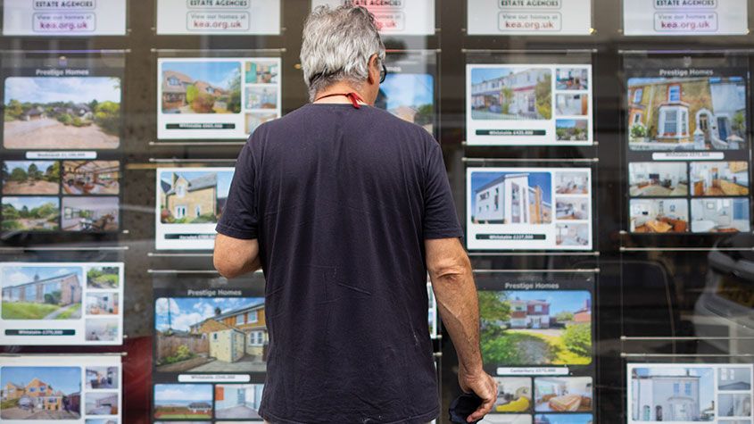 Man looking in the window of an estate agent