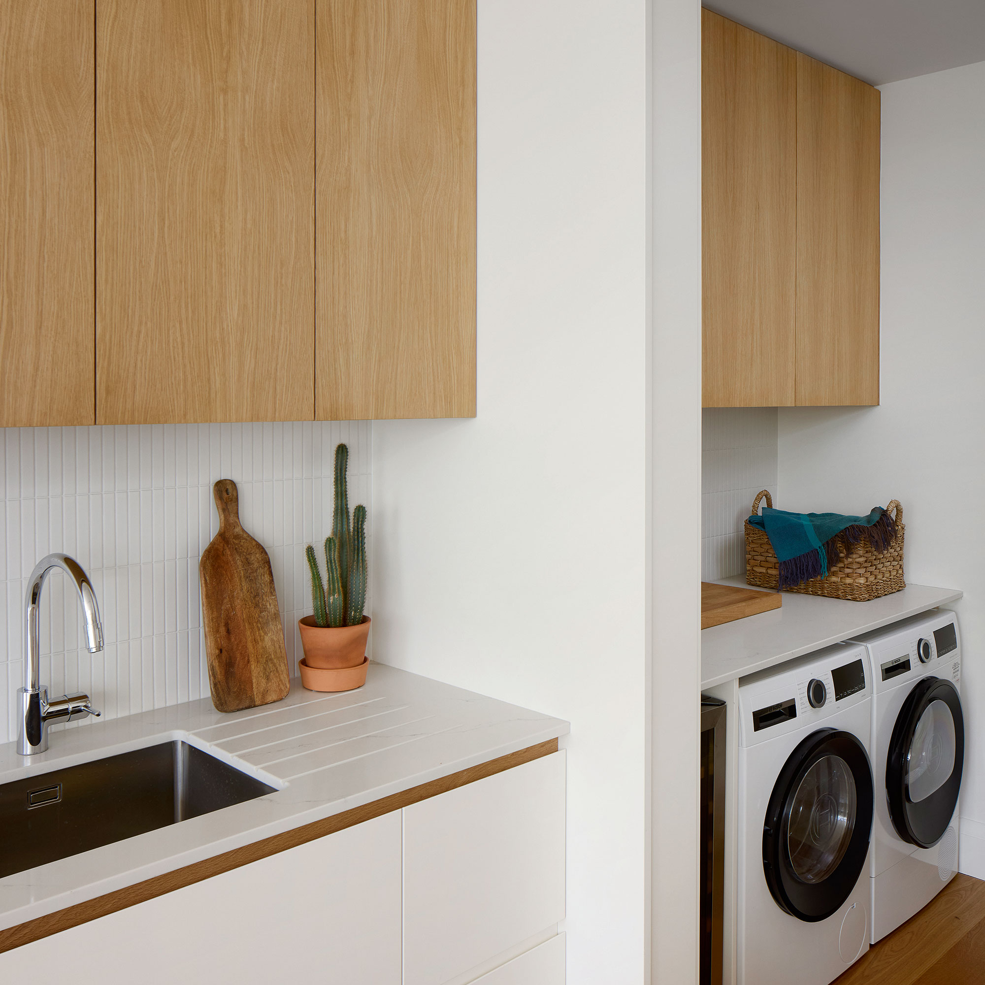 White and light wooden kitchen with utility room behind pocket doors