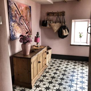 pink hallway with sideboard and patterned floor tiles