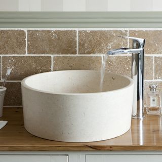 bathroom with stone basin and tiles wall