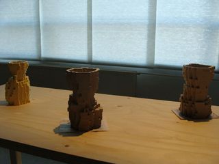 Three pixelated vases on a wooden table