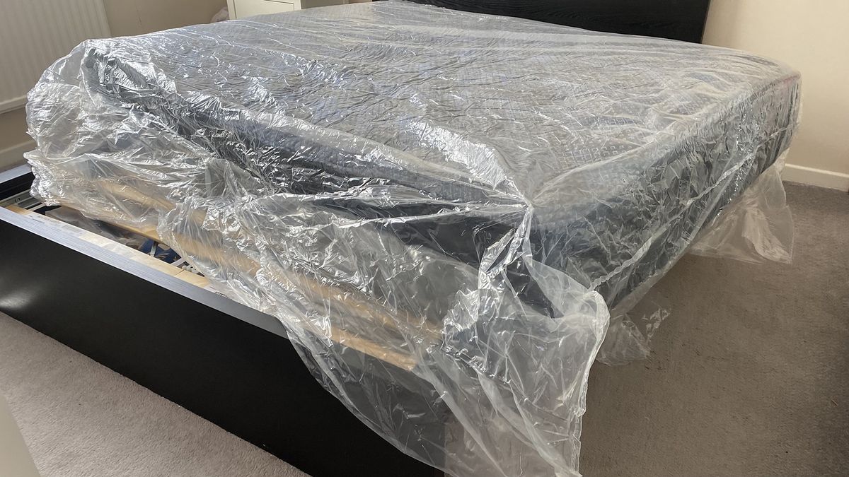 The Dreamstage Value Quilted Hybrid mattress unrolled but still in its packaging, on a bed frame in our tester's bedroom