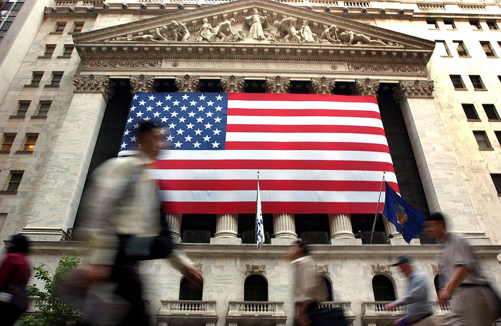 People walk on Wall Street.