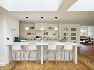All white kitchen with contrasting dark wood floor