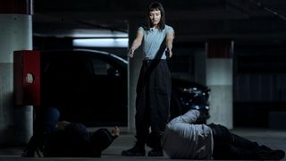 Max Meladze (Laura Haddock) standing over two men at gunpoint