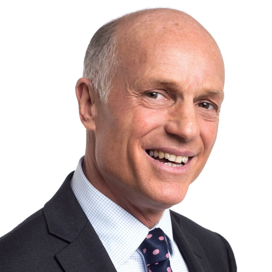 A man smiling at the camera wearing a suit and tie