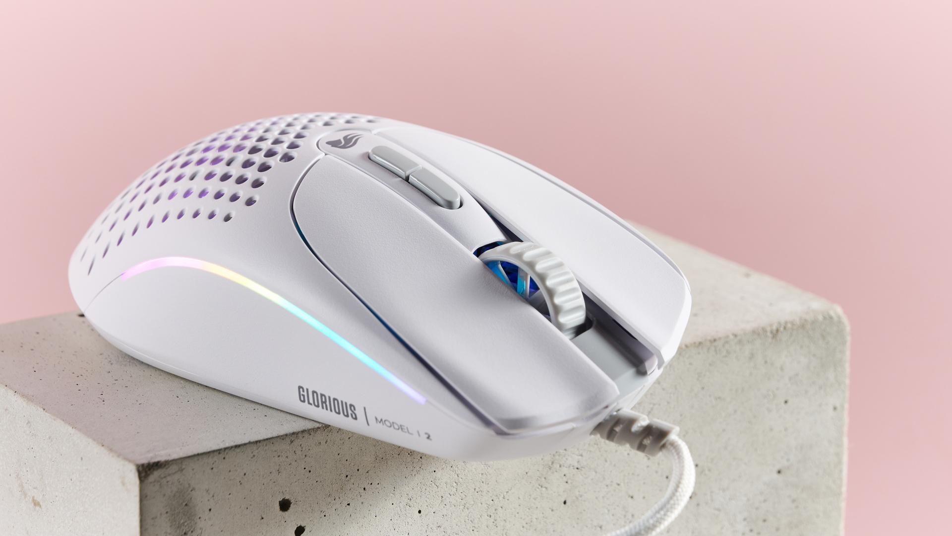 Front three-quarter view of Glorious Model I 2 with RGB lighting, on plinth with pink background