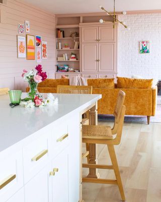 A white kitchen island with a rattan chair next to it