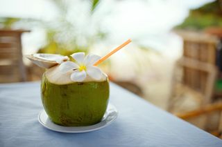 A coconut with a straw in it.