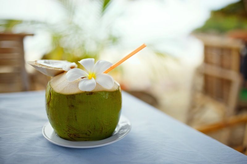 A coconut with a straw in it.