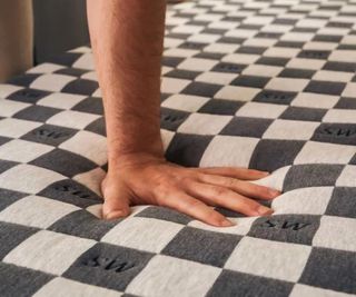 A hand pressing down on the SweetNight Prime Memory Foam Mattress.