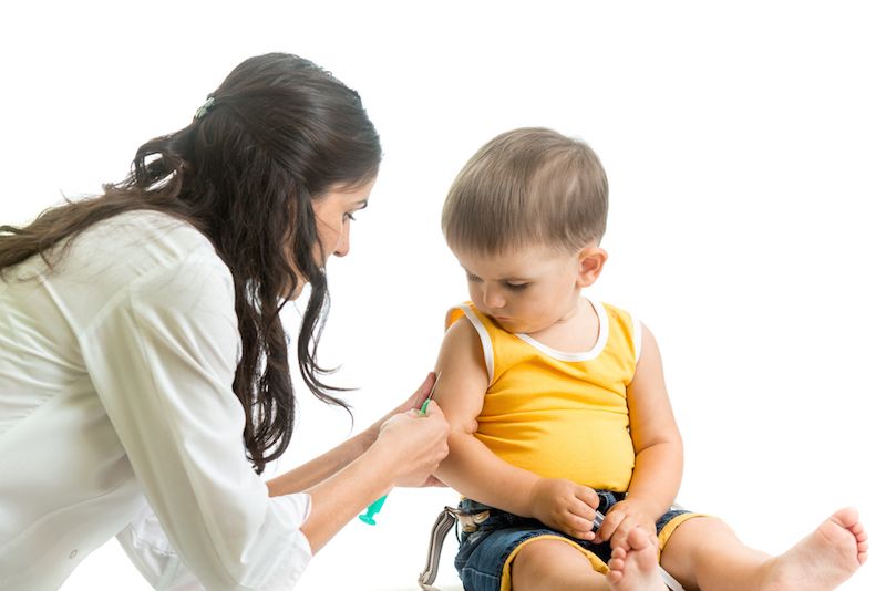 A young boy receives a vaccination from his doctor. 