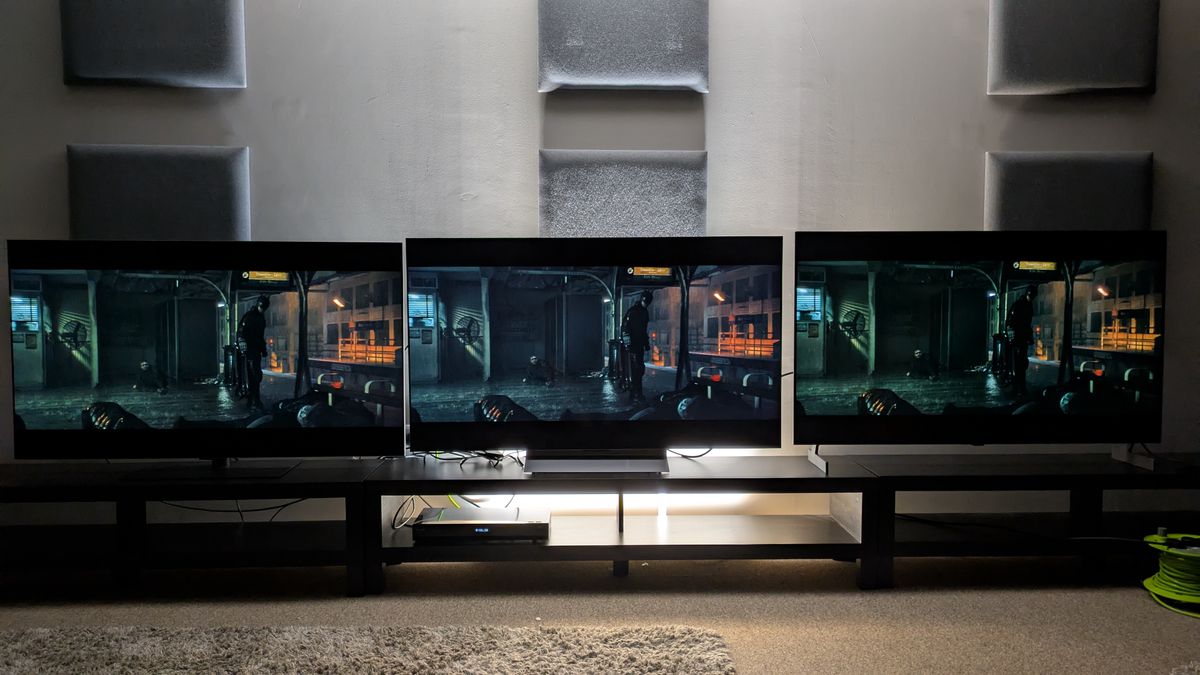 LG G6 (left) vs LG C6 (middle) vs LG B6E (right) showing Batman on a subway platform from The Batman. All three TVs have great contrast, but the C6 has the most accurate picture