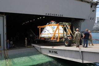 Caption: The Orion boilerplate test vehicle is loaded onto the USS Anchorage at the U.S. Naval Base in San Diego, California on July 29. A team of NASA engineers and U.S. Navy personnel will test out different techniques to haul the test spacecraft from the Pacific Ocean.