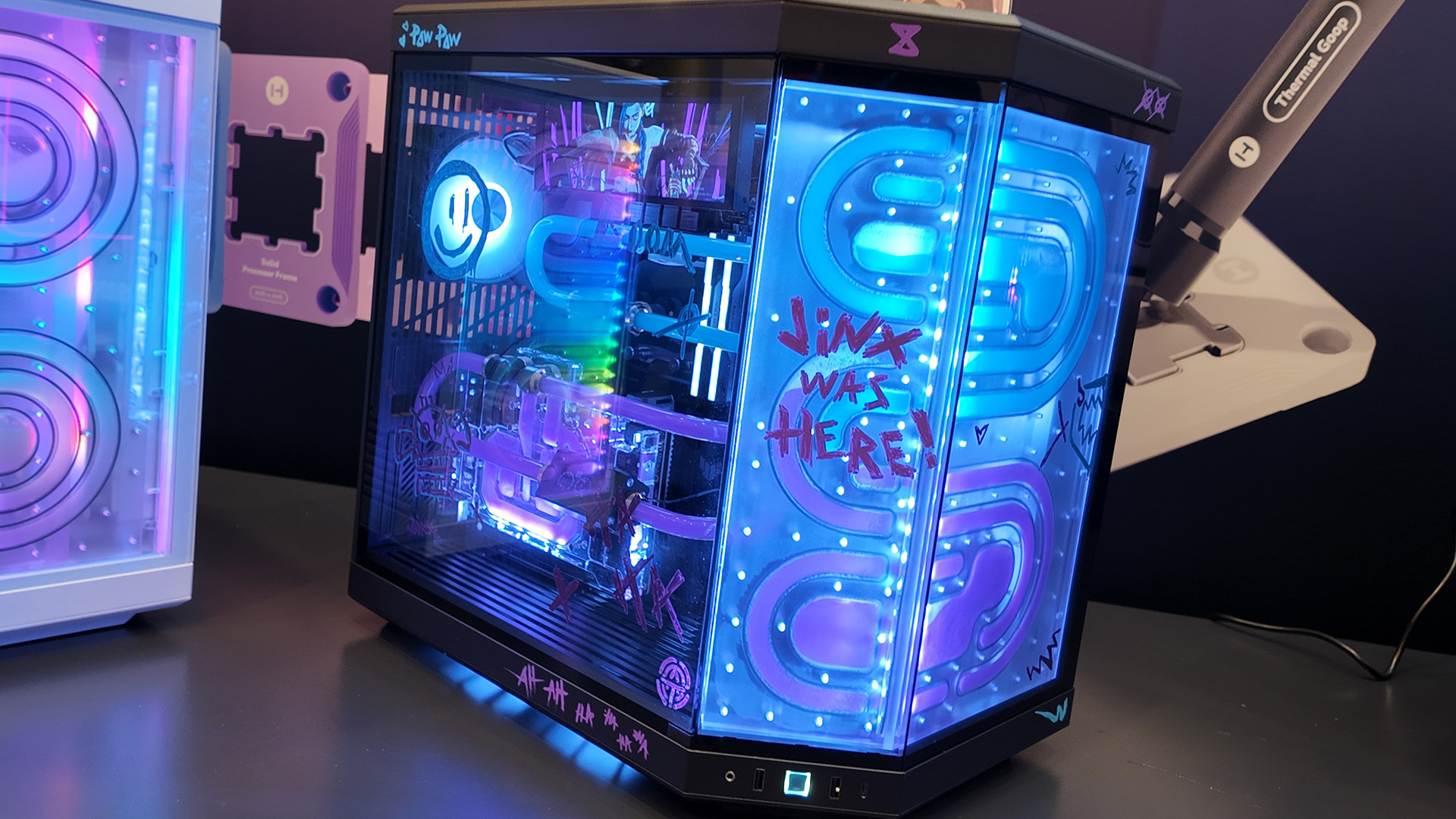 A gaming PC at the Hyte CES 2025 booth with a Bitspower distro plate and themed like Jinx from League of Legends.