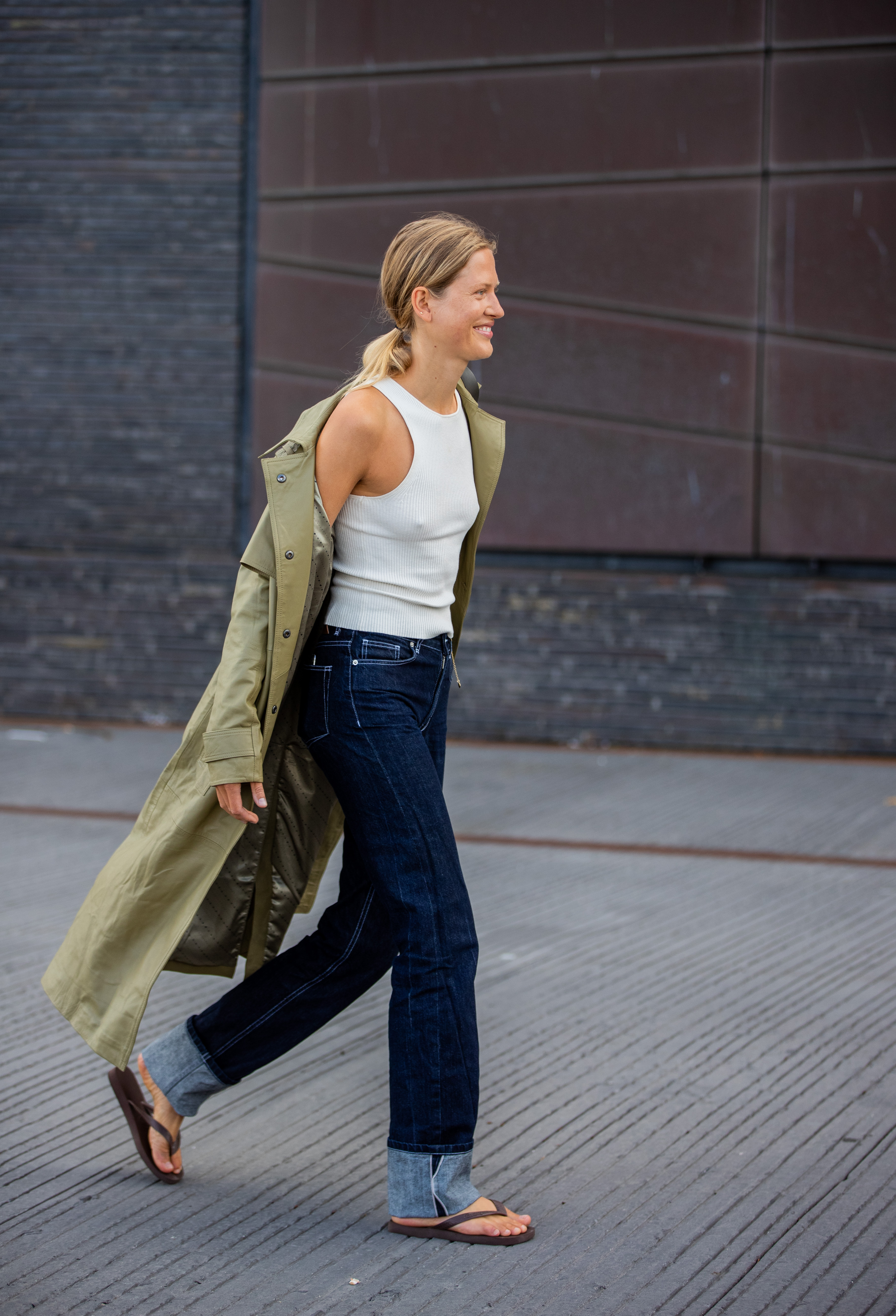 A guest is seen wearing olive trench, denim jeans outside Mother of Pearl on August 11, 2021 in Copenhagen, Denmark