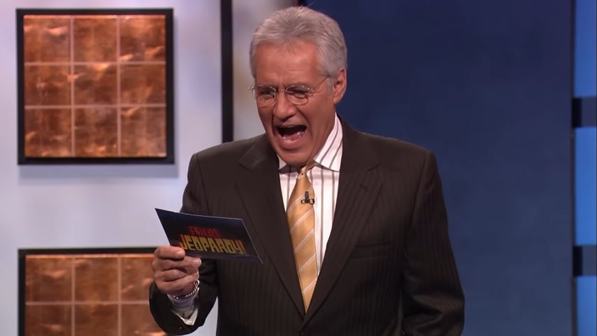 Alex Trebek reacts with an open mouth to a clue he&#039;s reading on an episode of Jeopardy!.