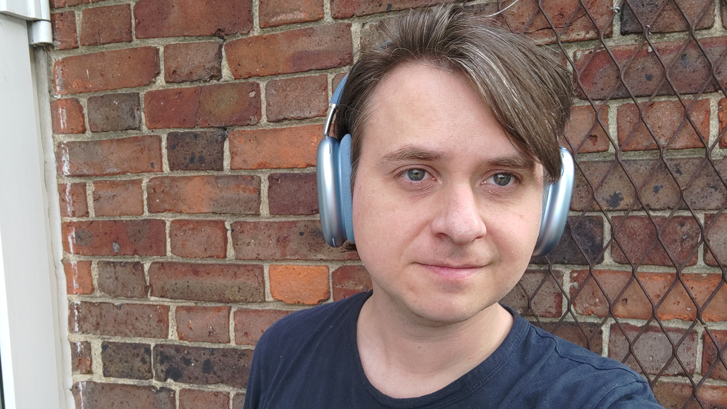 Photograph of man wearing Apple AirPods Max 2 headphones