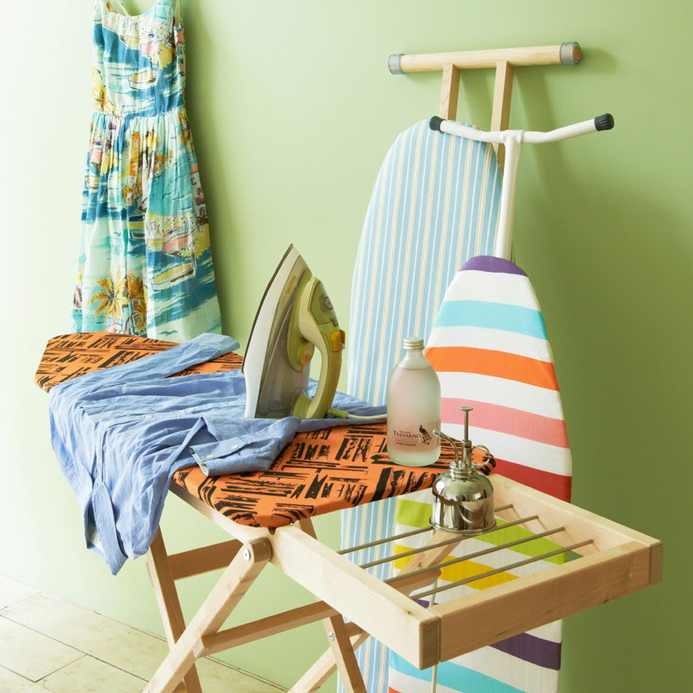 room with green wall and iron on wooden table