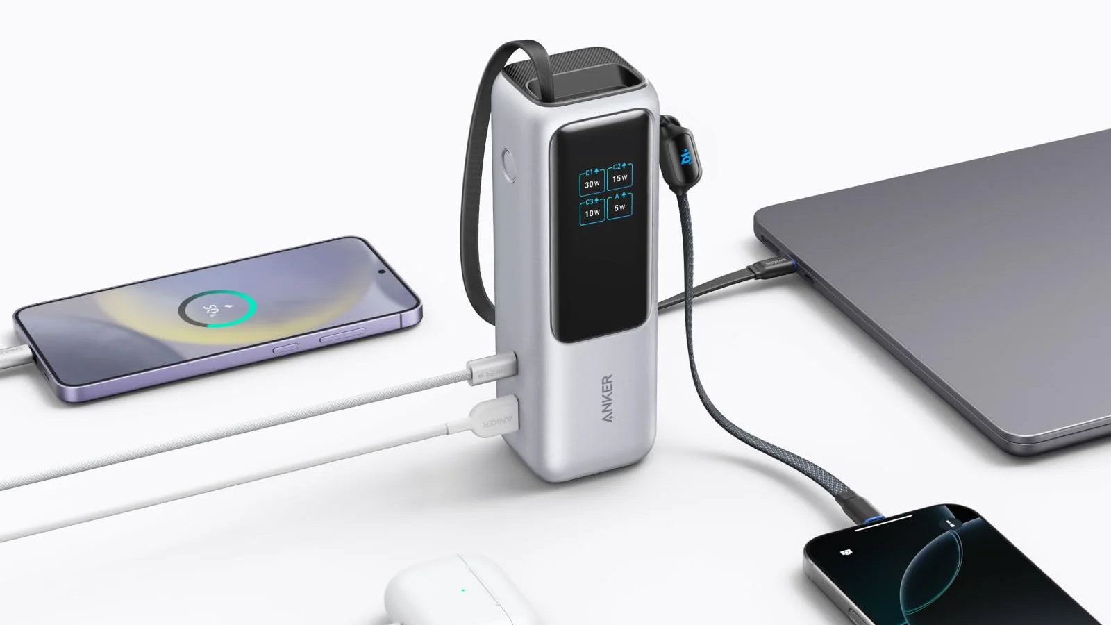 An Anker Power Bank 25K surrounded by two phones and a laptop