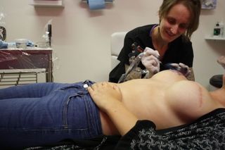 Nikki Black getting tattoos on her scarred breasts by female tattoo artist