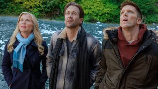 From left to right: Alison Sweeney, Niall Matter and Victor Zinck Jr. all wearing winter coats and looking up in This Time Each Year. 