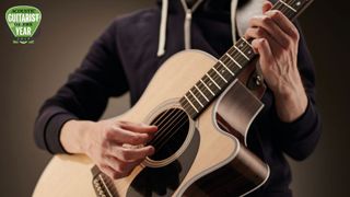 Close-up of acoustic guitar player