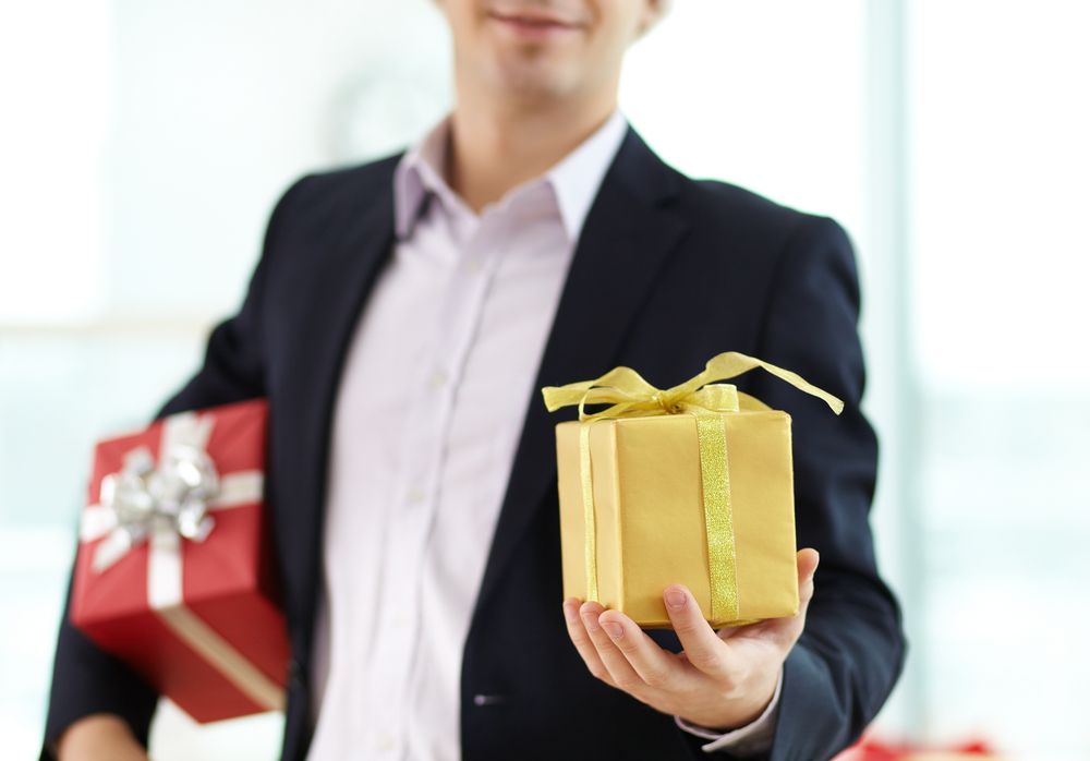 Image of businessman showing gift in his hand