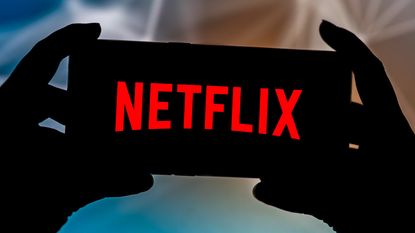 Netflix logo on phone in dark