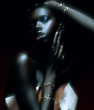 Model wears gold squiggle jewellery