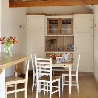 dining area with wooden floor and white wall and dining table and chairs