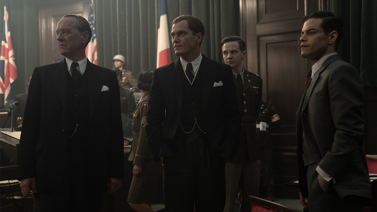 From left to right, Richard E. Grant, Michael Shannon, and Rami Malek in suits in Nuremberg